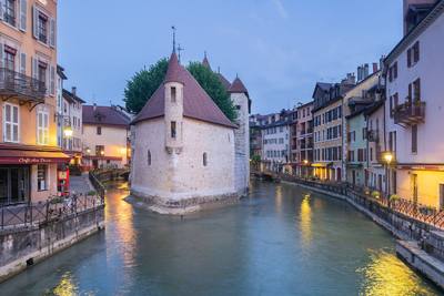 The Palais de l'Isle and the canal in Annecy's old town at dusk.